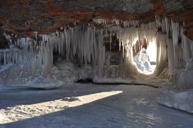 Sunset glow lighting the ice formations of Apostle Islands sea caves