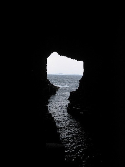 Inside view of Fingal’s Cave with columned walls and tidal water