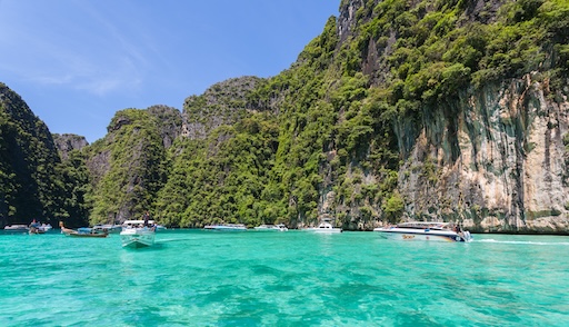 Tourists walking on the white sand of Maya Bay
