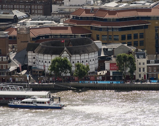 Live performance at the Globe Theatre with audience surrounding the stage