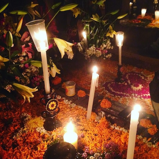 Family altar with candles and photos for Día de Muertos in Mixquic